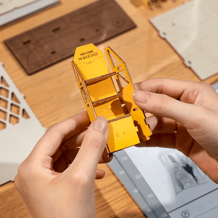 DIY Garden House Book Nook Kit by Diokits Being Assembled By a Person