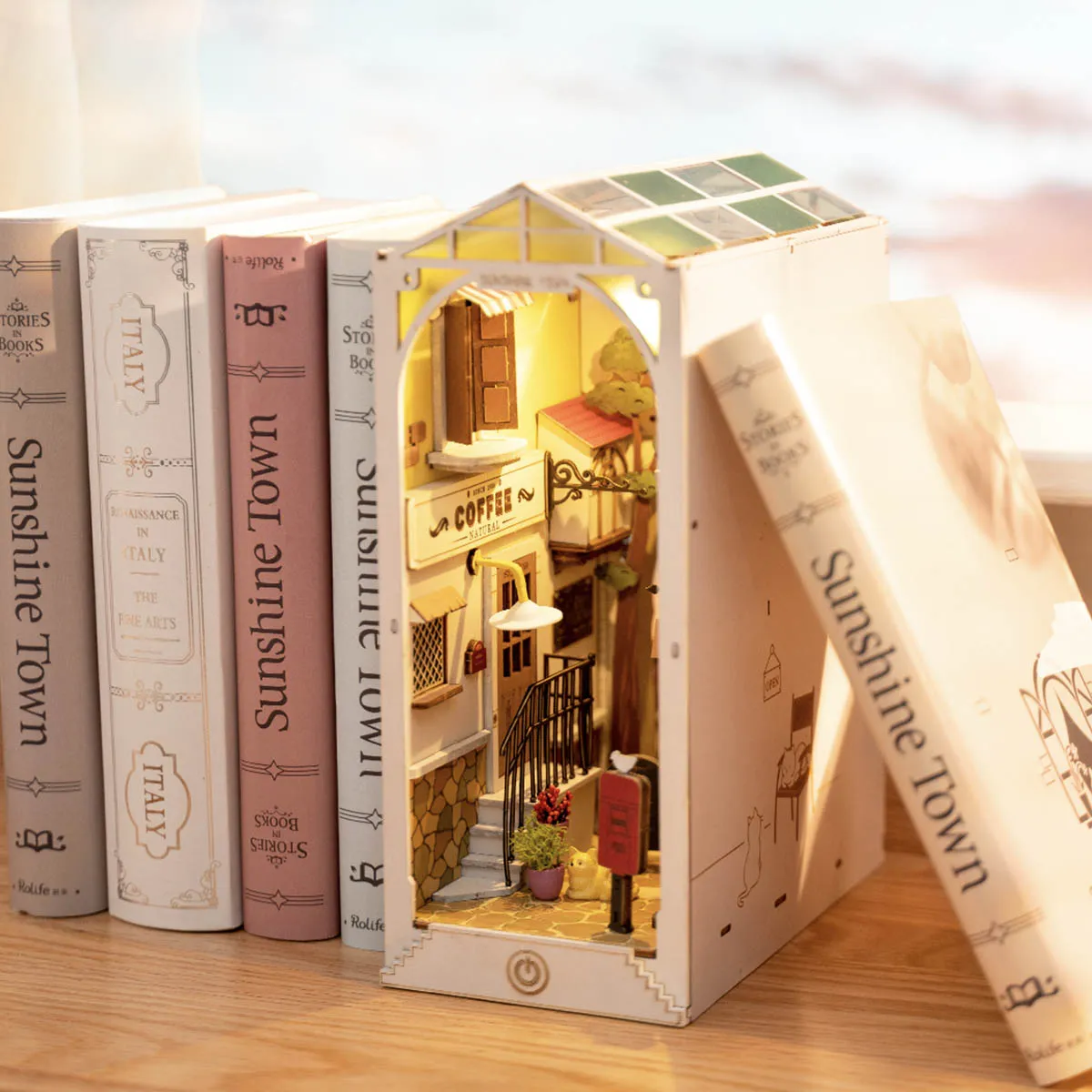 DIY Sunshine Town Book Nook Kit by Diokits - Front Angled View of Book Nook in Middle of Books